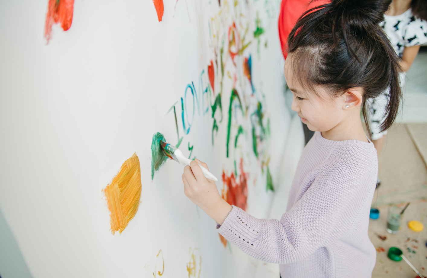 壁に絵の具でお絵かきする様子